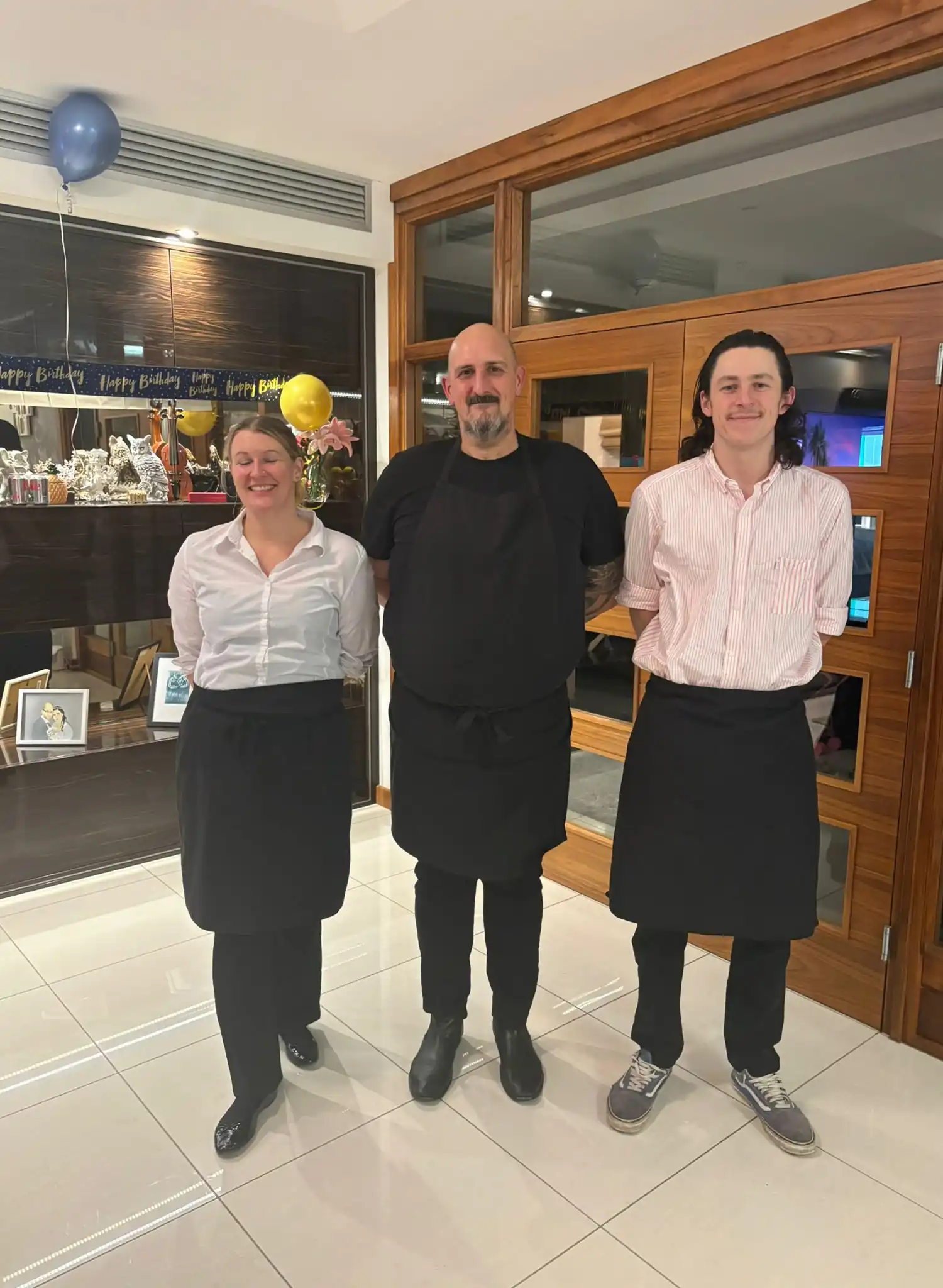 Chef Tom and his catering team at a private birthday party in Bournemouth, dressed in black aprons and ready to serve