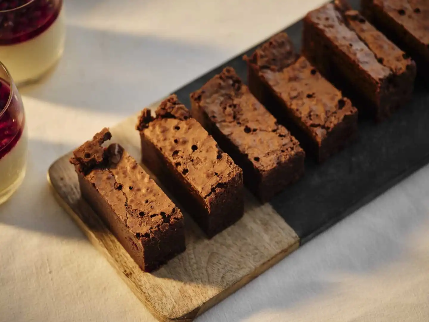 Sliced fudgy chocolate brownies on a rustic wooden board served as a dessert course by an event caterer in Bournemouth