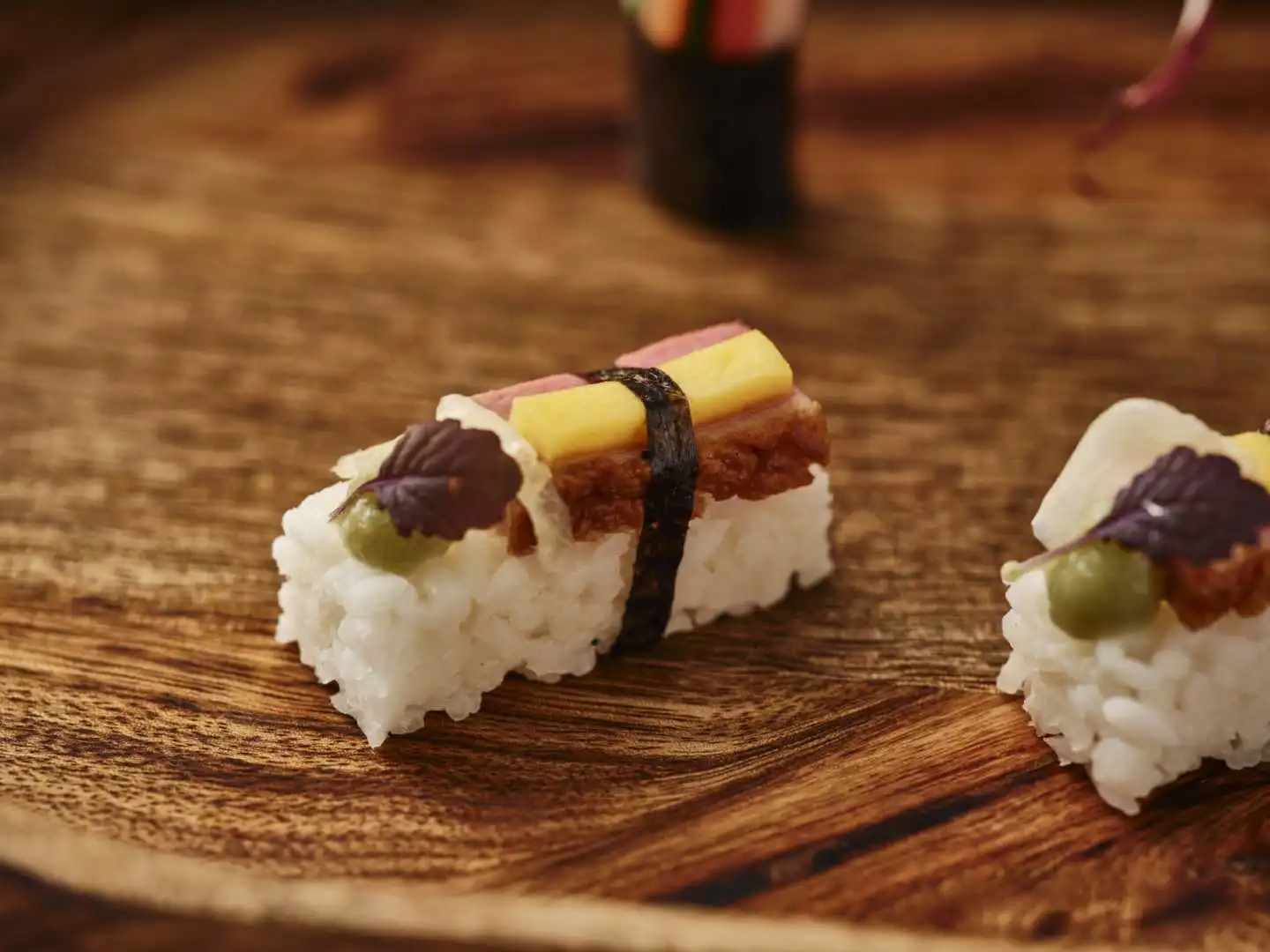 Fusion nigiri canapes with cured meat, green olive and shiso leaf on a wooden board at a Bournemouth catered cocktail reception