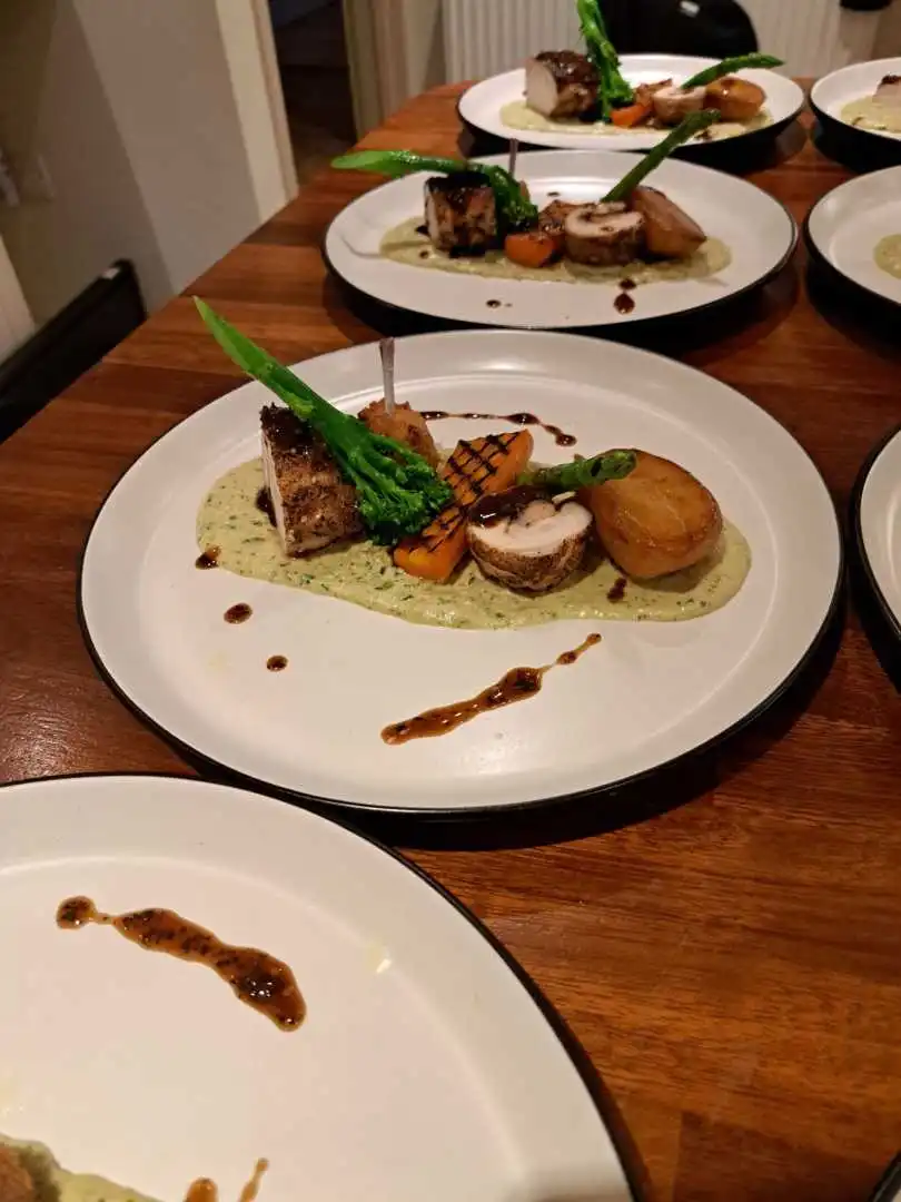 Plated pork belly and rolled pork with fondant potato, tenderstem broccoli and herb sauce served at a private catered dinner in Bournemouth